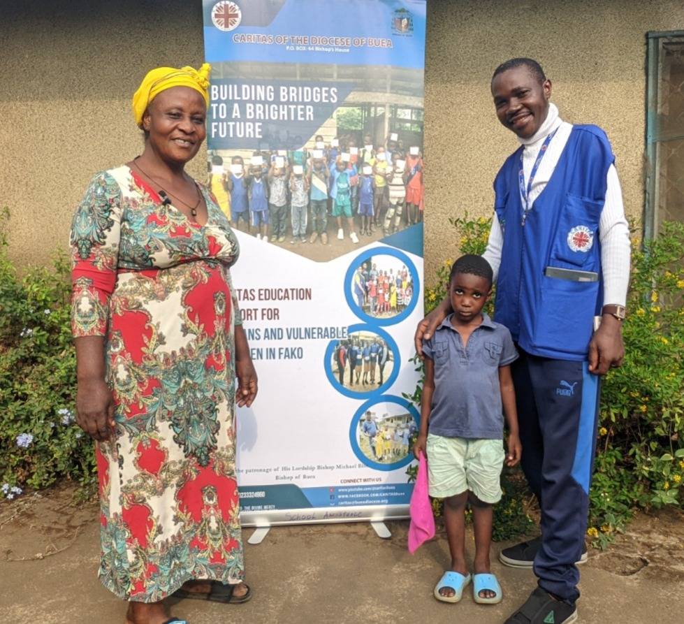 CARITAS staff alongside guardian and child, beneficiaries of educational support.